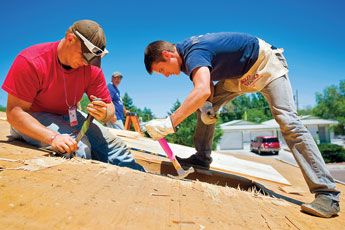 Levi Hall, left, and Josh Lambert work on repairing a roof at a World Changers work site in Gallup Tuesday. © 2011 Gallup Independent / Cable Hoover 